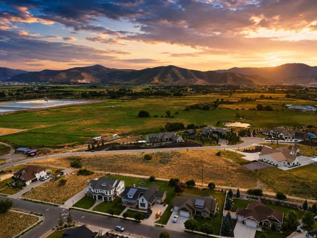 Aerial perspective showcasing residential properties within a developed neighborhood, framed by expansive natural landscaping and distant mountains