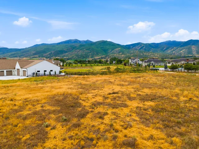 Expansive land parcel featuring natural, dry ground cover and distant mountain ranges