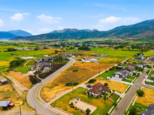 Expansive aerial perspective showcasing a residential development with mountain and distant water features