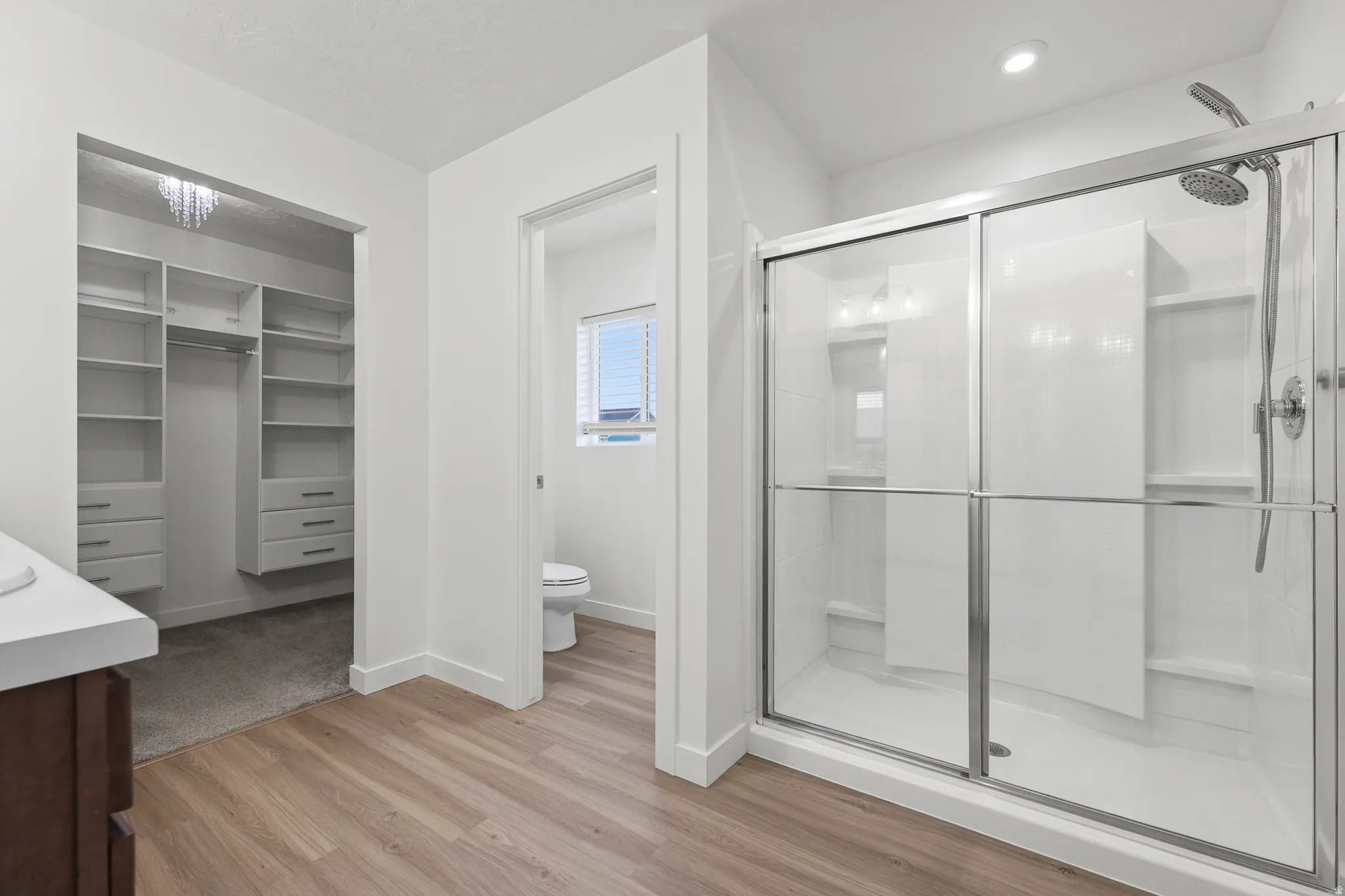 Primary bathroom walk-in shower with sliding glass doors