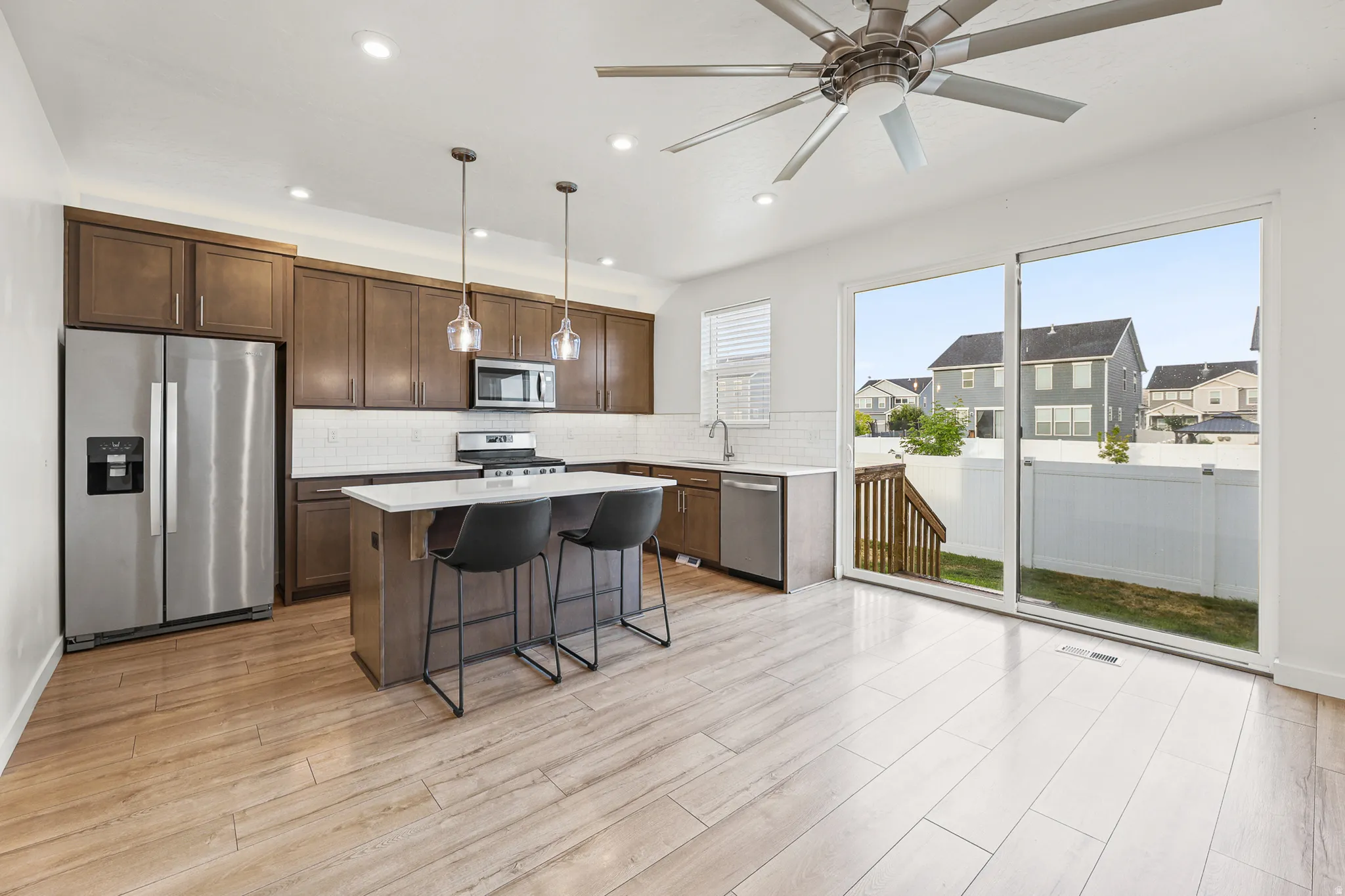 Modern kitchen featuring included stainless steel appliances, dark wood cabinetry, and a white subway tile backsplash