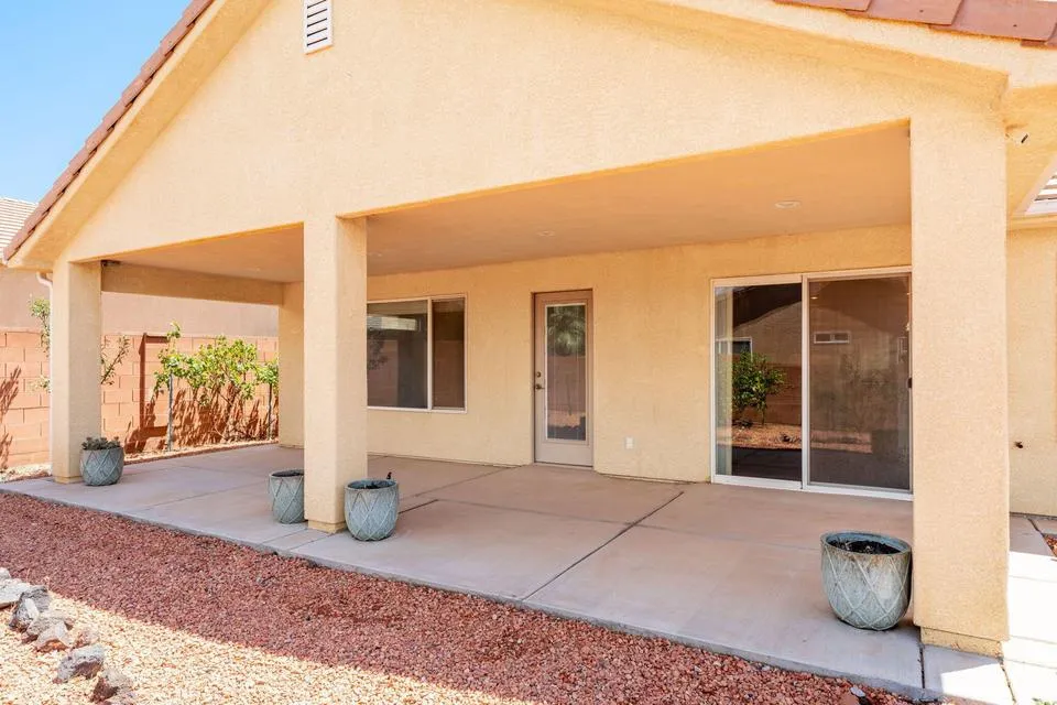 Expansive covered patio with concrete slab, stucco columns, and an integrated roofline