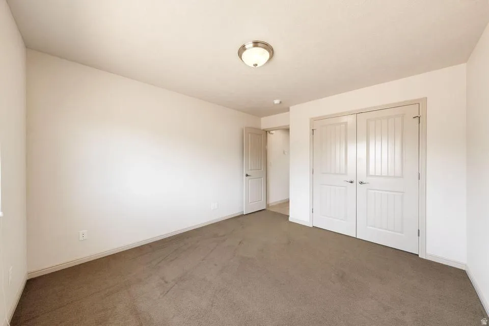Neutral-toned carpet flooring complemented by white baseboards and walls