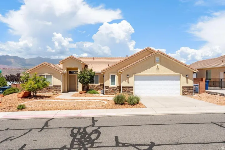 Stucco exterior with stone accents and a terracotta-style tile roof
