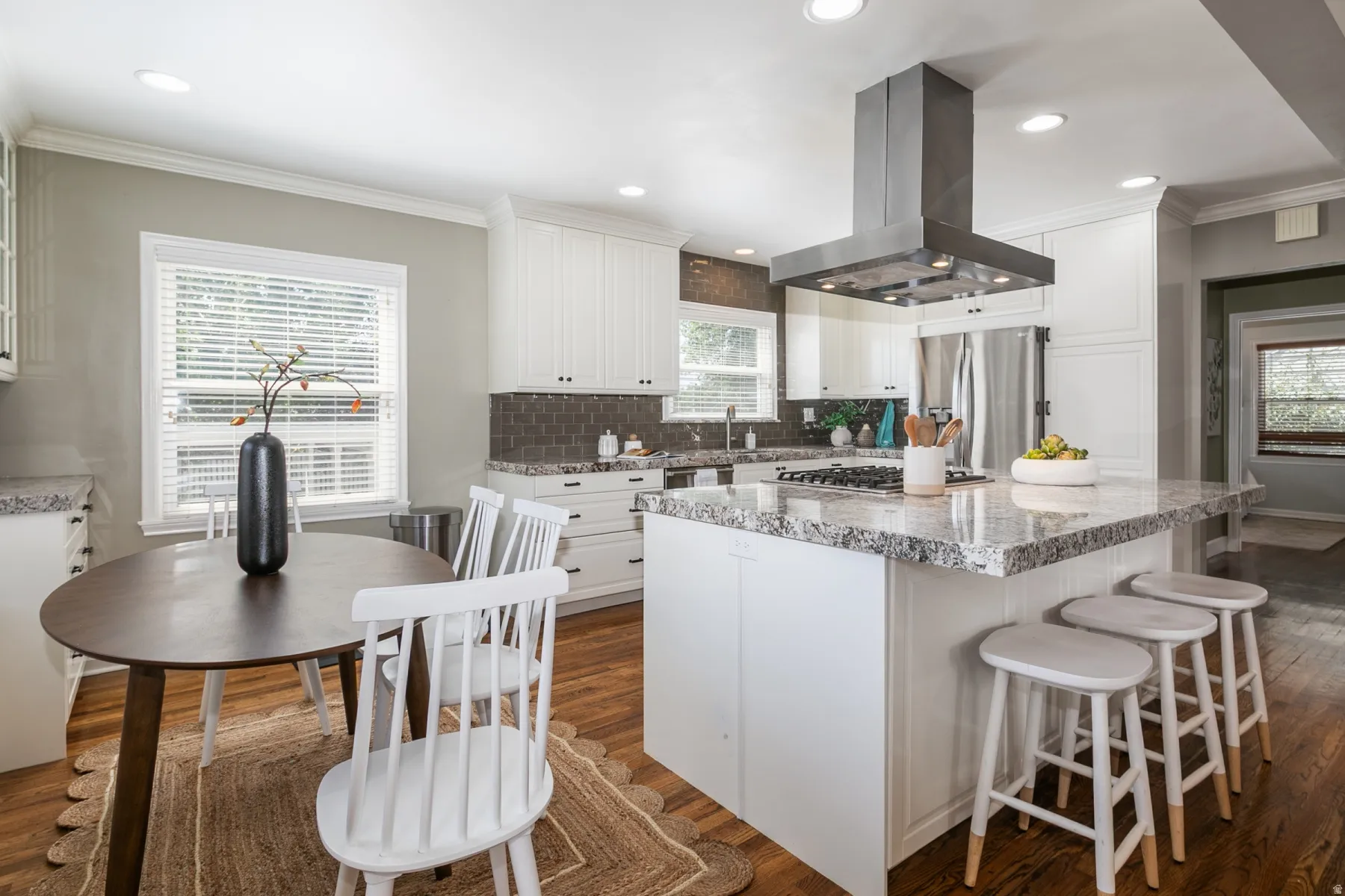 Kitchen featuring white shaker-style cabinetry, a central island with a granite countertop, and stainless steel appliances