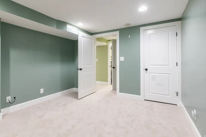 Spacious room featuring plush carpeting, recessed lighting, and crisp white trimwork