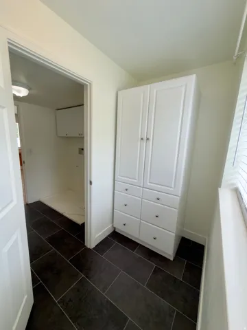 Storage closet in half bath. Behind the cabinet it is already plumbed for a shower