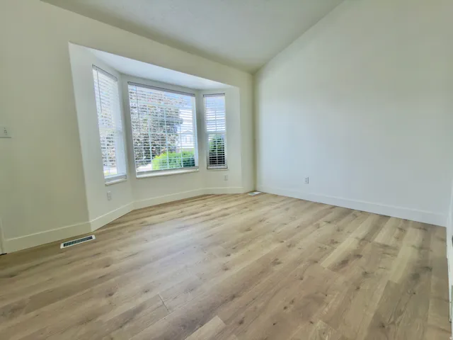 Formal living room with bay window, vaulted ceilings & new LVP flooring