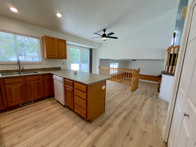 Kitchen & dining featuring LVP flooring, shaker-style wood cabinetry, and a central island with countertop seating
