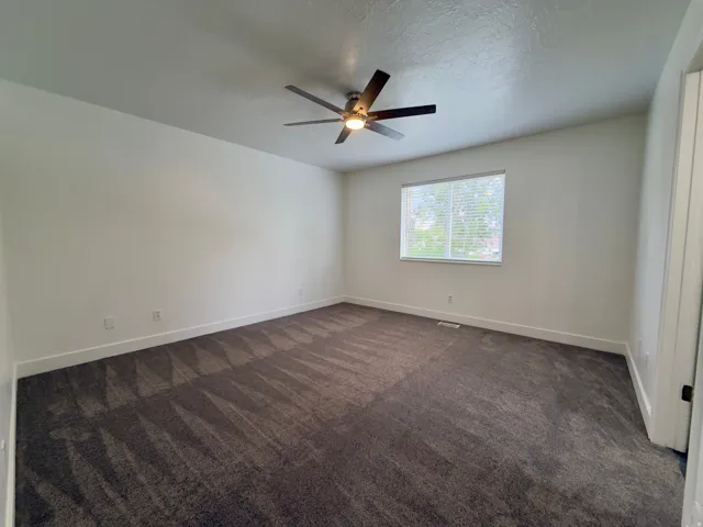 Large primary bedroom with ceiling fan