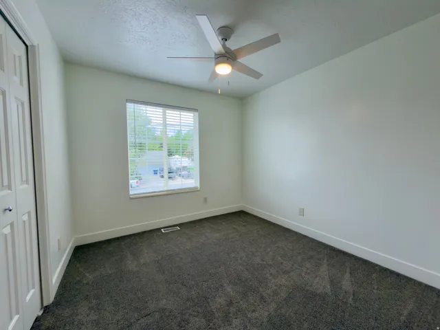 Top floor bedroom featuring a ceiling fan with integrated lighting