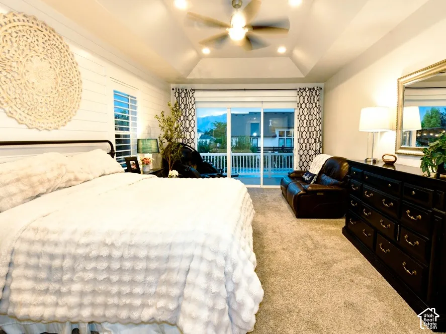 Spacious bedroom featuring a tray ceiling with recessed lighting and a ceiling fan
