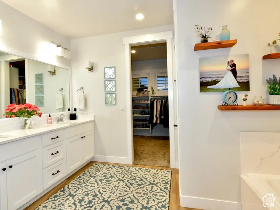 Bright bathroom featuring a double vanity with white cabinetry, dual undermount sinks, and a light-toned countertop