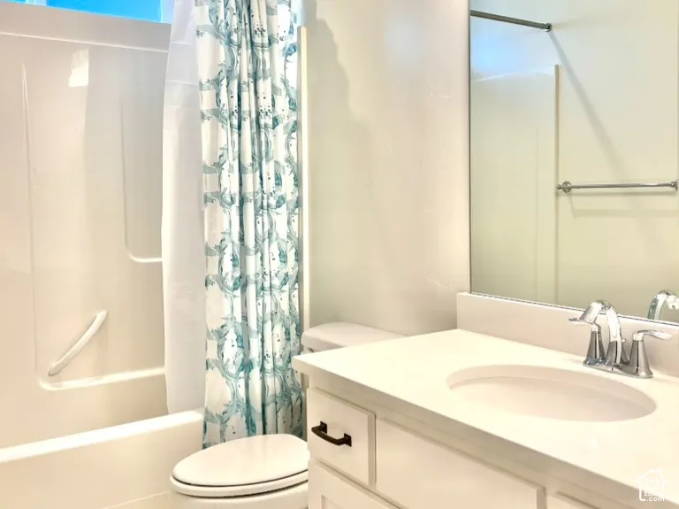 Bathroom featuring a white vanity with a light-toned countertop, a rectangular mirror, and a three-light fixture