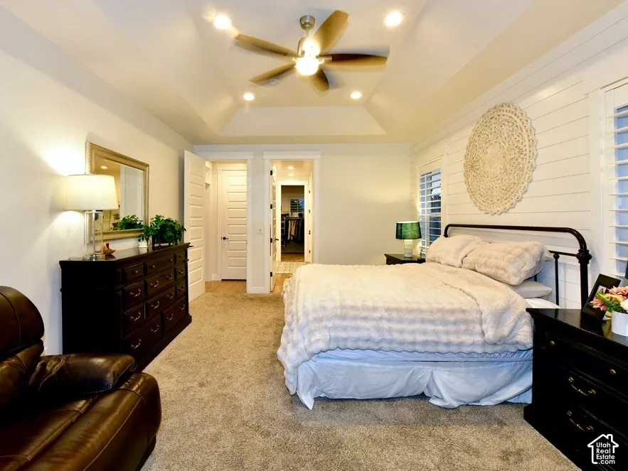 Spacious room featuring a tray ceiling, recessed lighting, and a ceiling fan