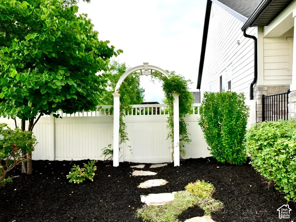 Garden archway with climbing foliage and stone paver pathway