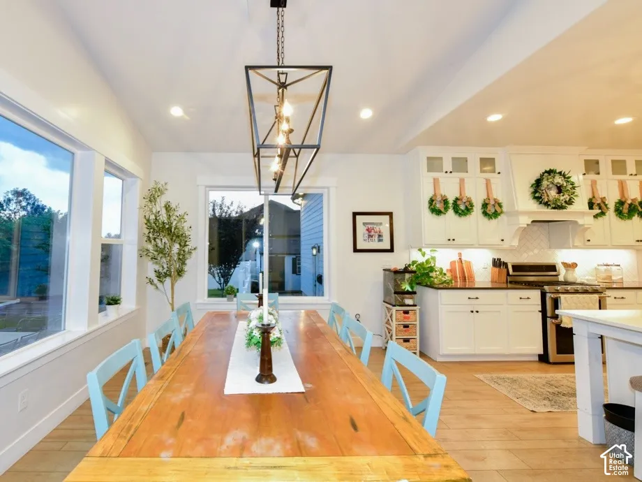 Open-concept dining and kitchen space featuring a striking linear chandelier