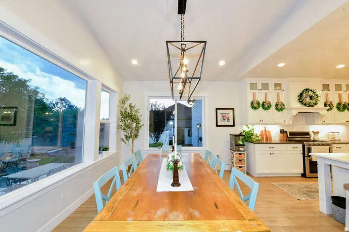 Open-concept dining and kitchen space featuring a striking linear chandelier