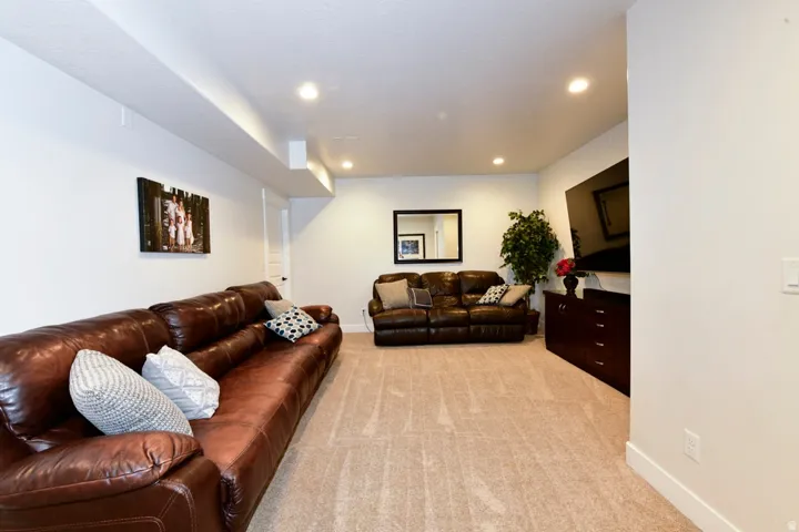 Spacious open-concept room featuring neutral carpet and recessed lighting