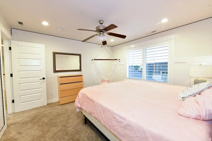 Room featuring carpet flooring, a multi-paneled door with dark hardware, and recessed ceiling lighting