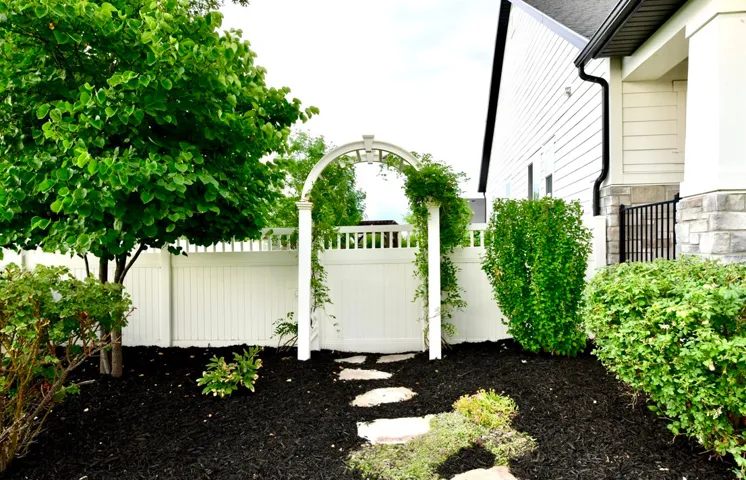 Garden archway with climbing foliage and stone paver pathway