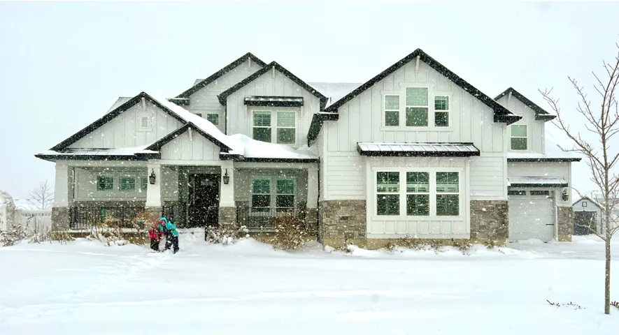 Modern farmhouse architectural style featuring white board and batten siding and stone accents