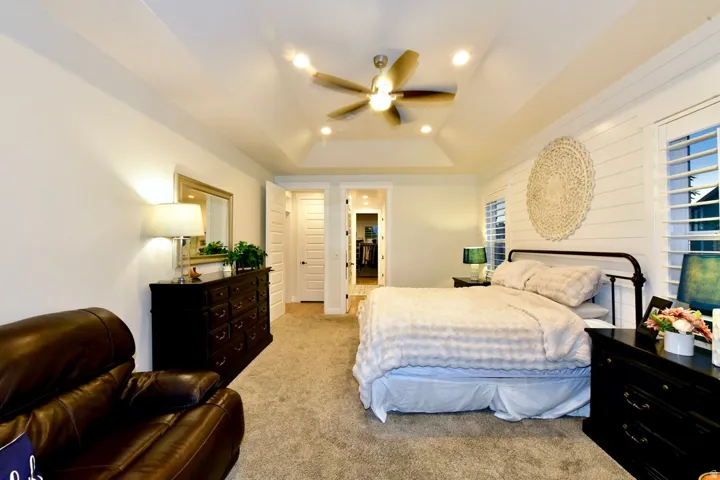 Spacious room featuring a tray ceiling, recessed lighting, and a ceiling fan