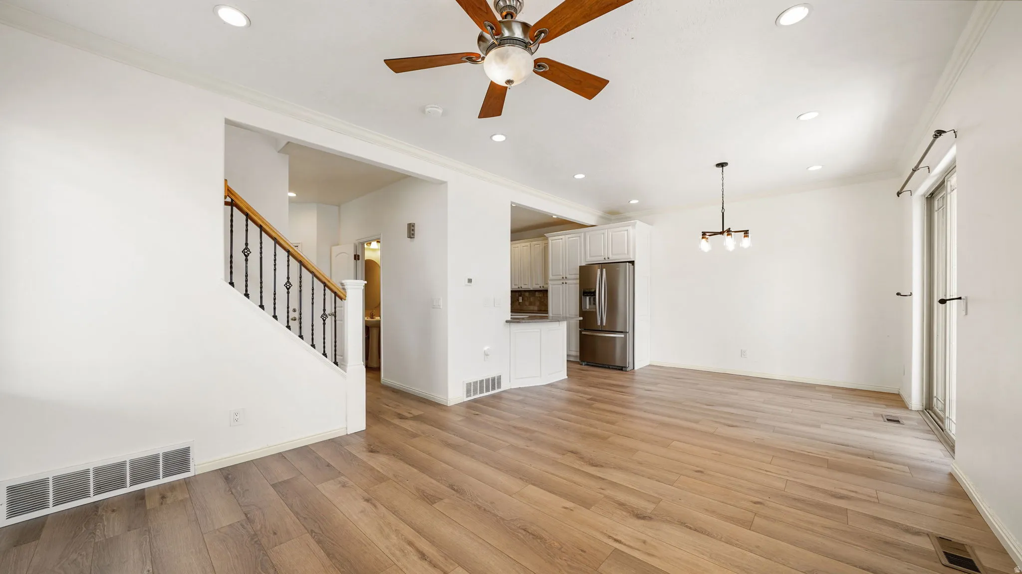 Open concept living space featuring wood-finish flooring, recessed lighting, and a modern ceiling fan