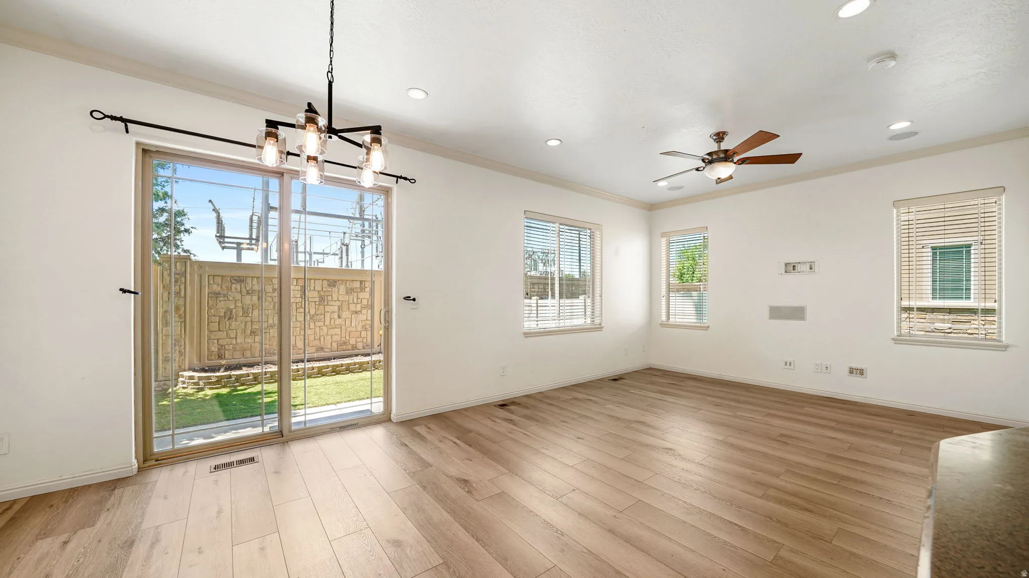 Bright interior space featuring wood-finish flooring, recessed lighting, and crown molding
