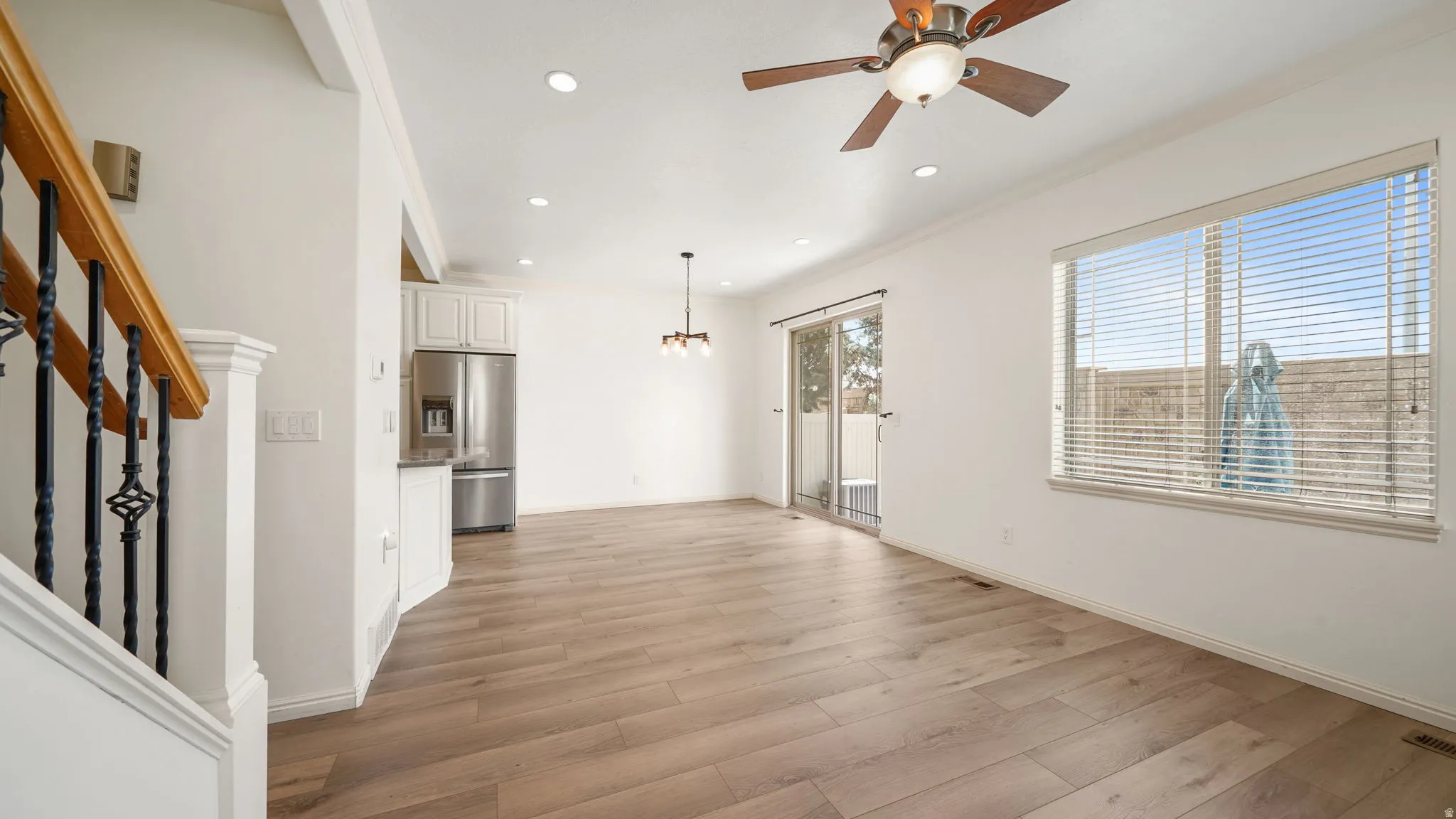 Spacious open-concept living area featuring wood-finish flooring, recessed lighting, and a ceiling fan