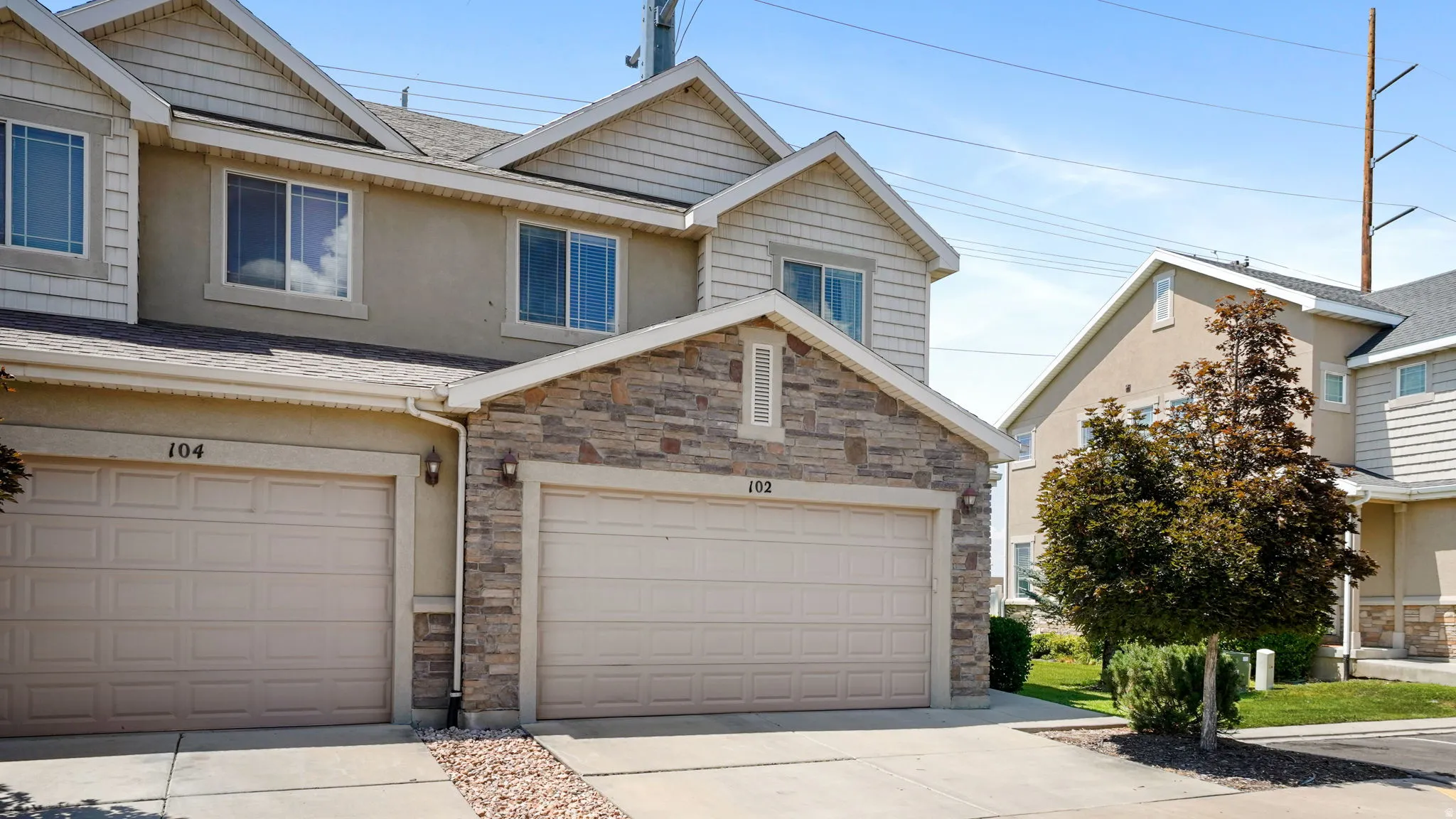 Two-story residential exterior featuring a stone and stucco facade