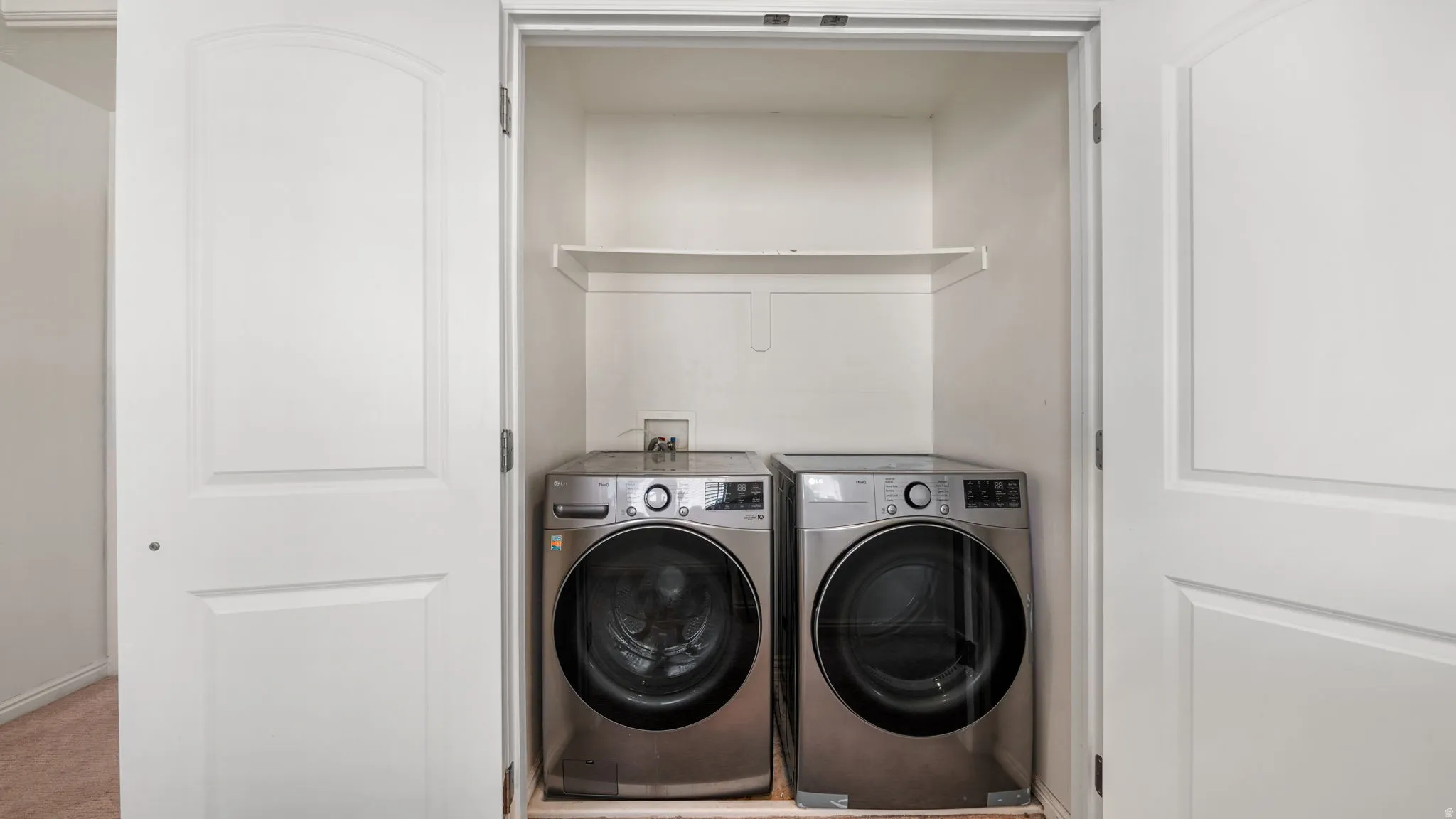 Dedicated laundry closet featuring a white shelf for storage