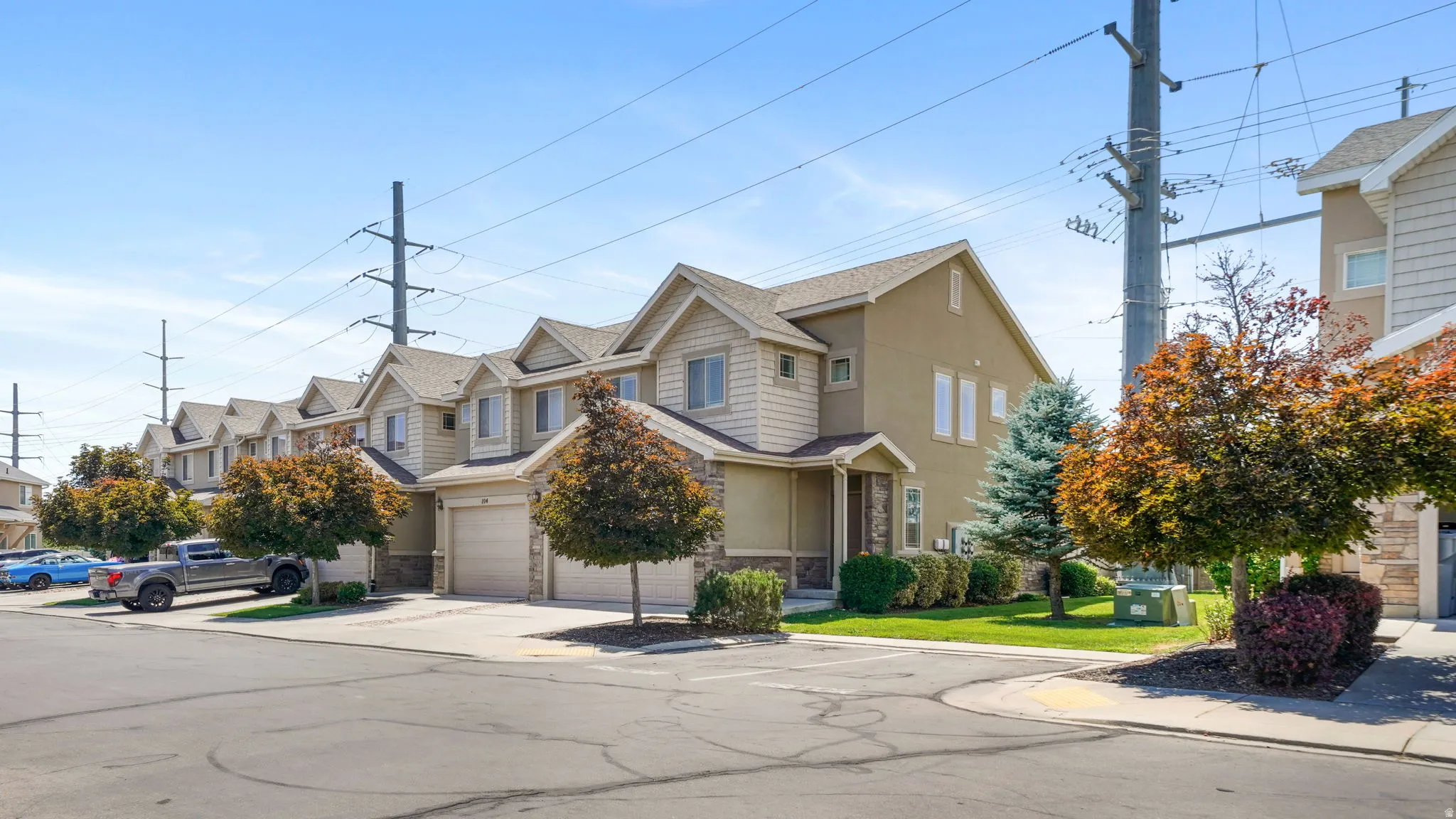 Two-story townhome featuring a neutral stucco and beige siding exterior
