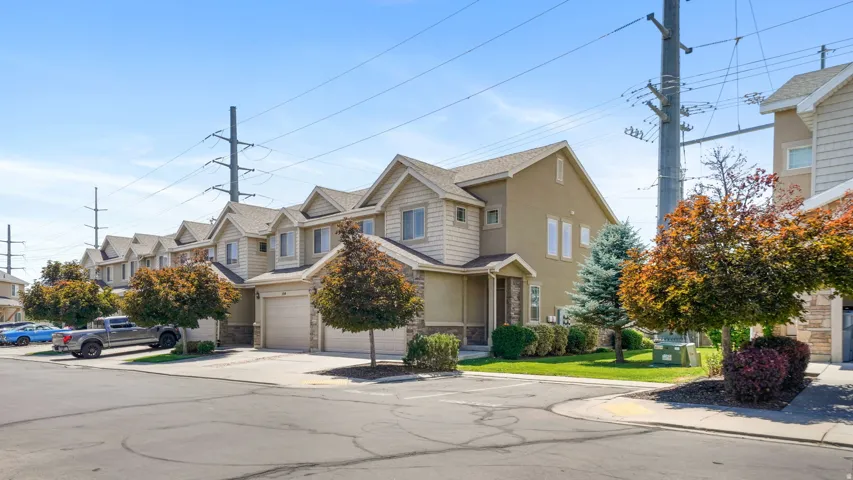 Two-story townhome featuring a neutral stucco and beige siding exterior