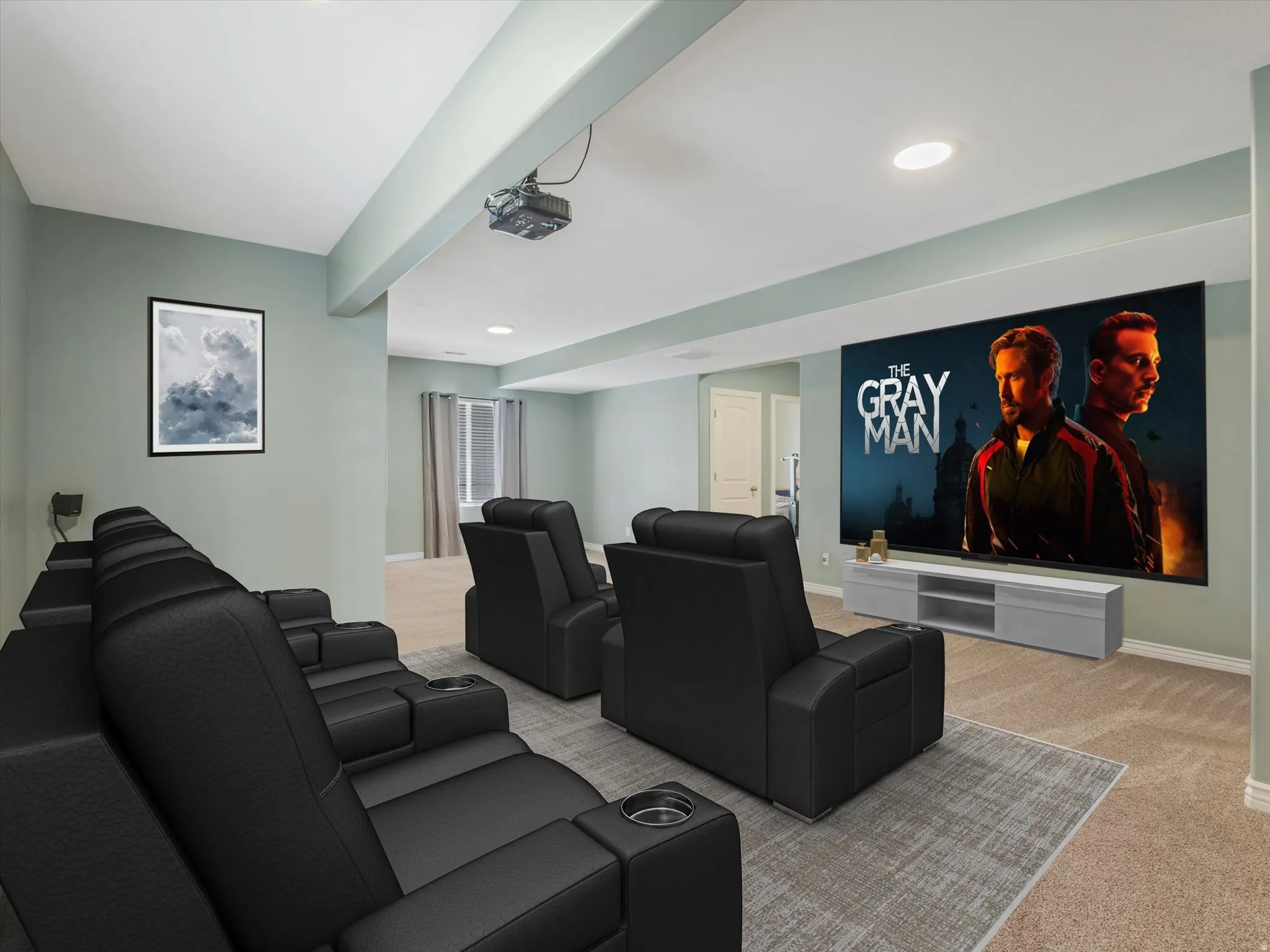 Dedicated media room featuring a large projection screen, recessed lighting, and soft carpet flooring