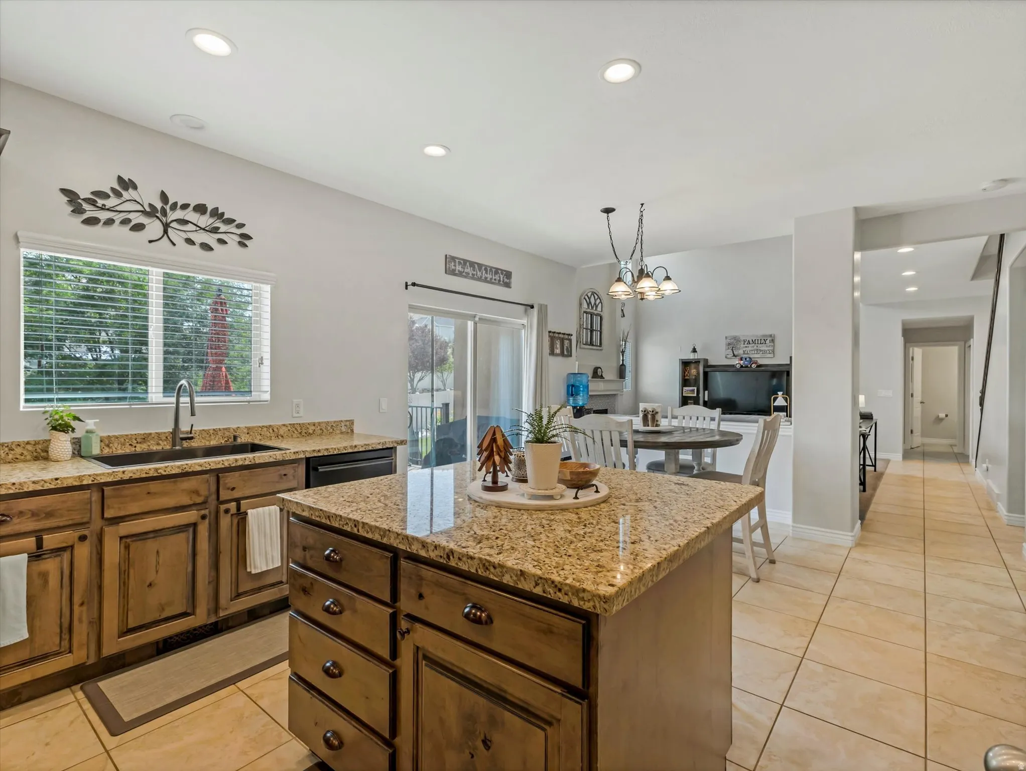 Kitchen featuring wood-finish cabinetry, granite countertops, and a central island