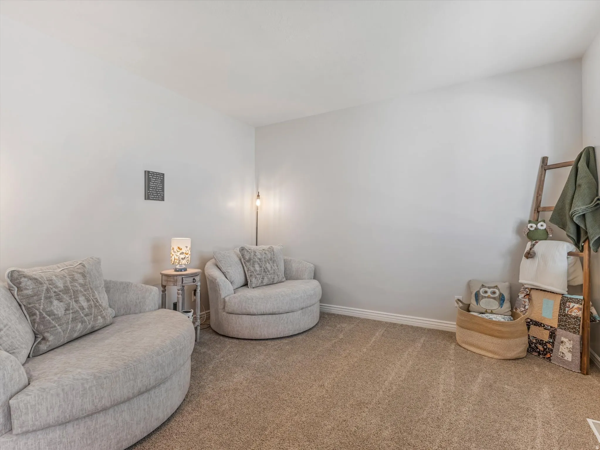 Neutral tone wall paint, carpet flooring, baseboard trim, and a built-in wall niche