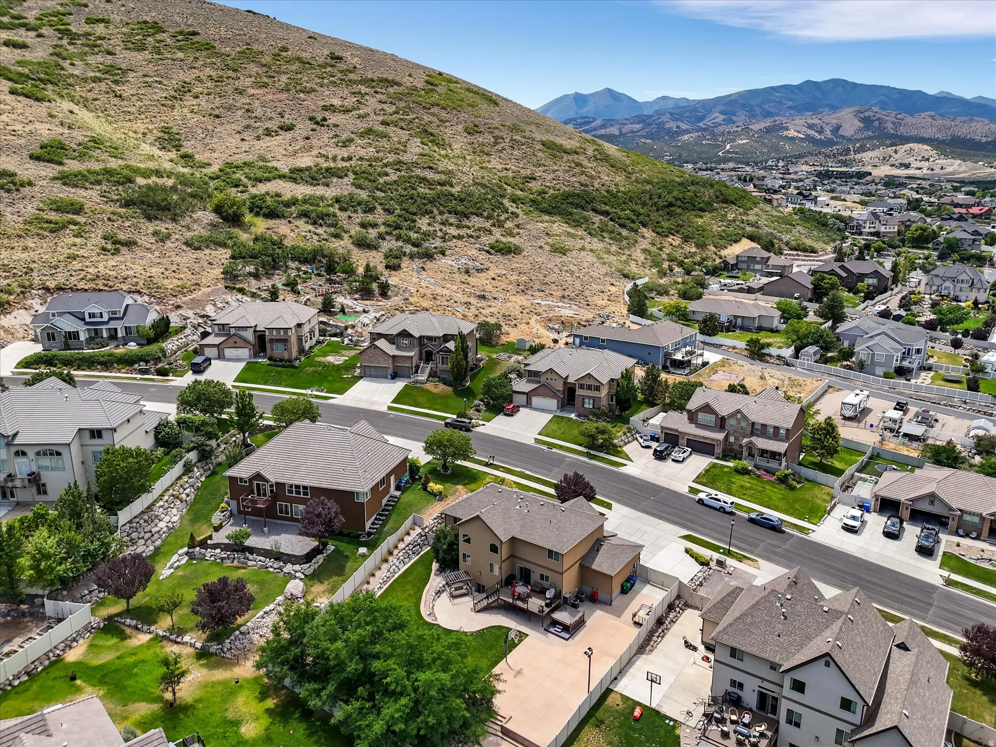 Residential neighborhood featuring a paved street, established homes with gabled roofs, and manicured lawns