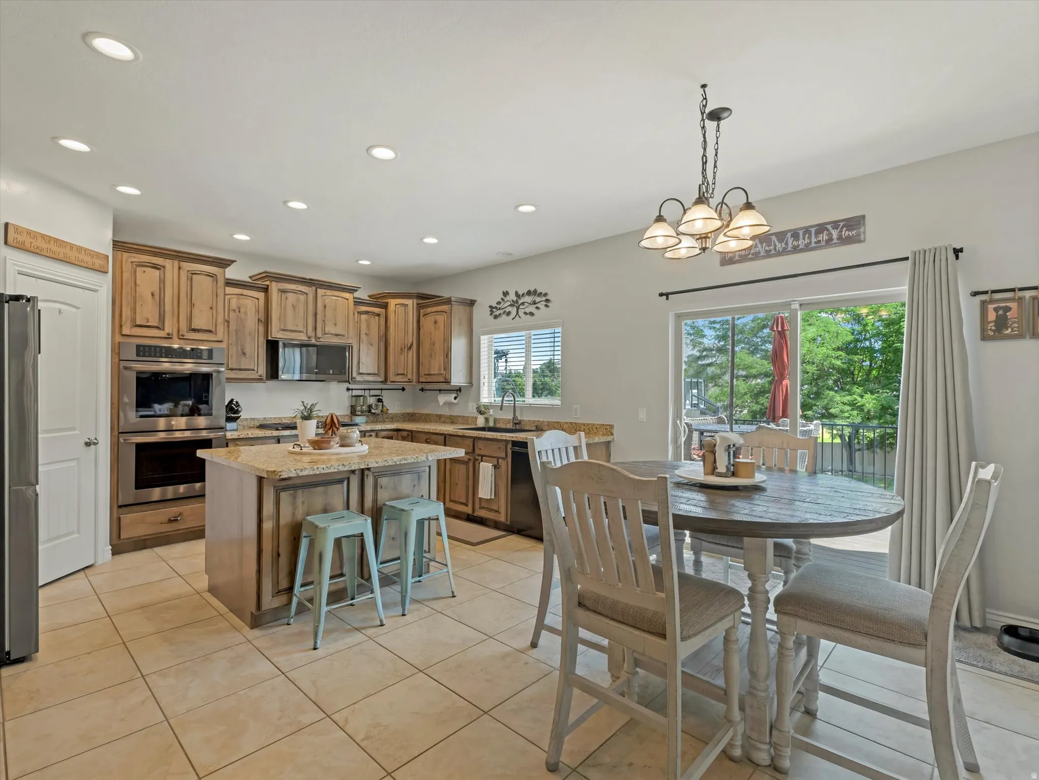 Kitchen featuring wood cabinetry, stainless steel appliances, granite countertops, and a central island