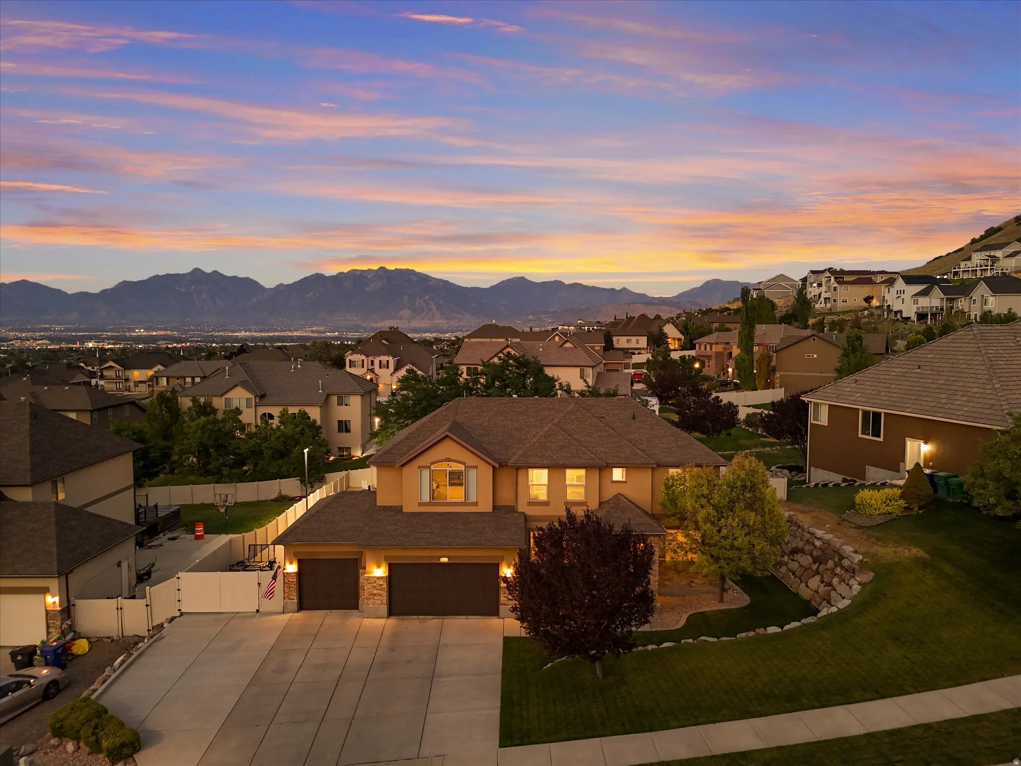 Elevated property featuring a two-story residence with a two-car garage and a stone facade accent