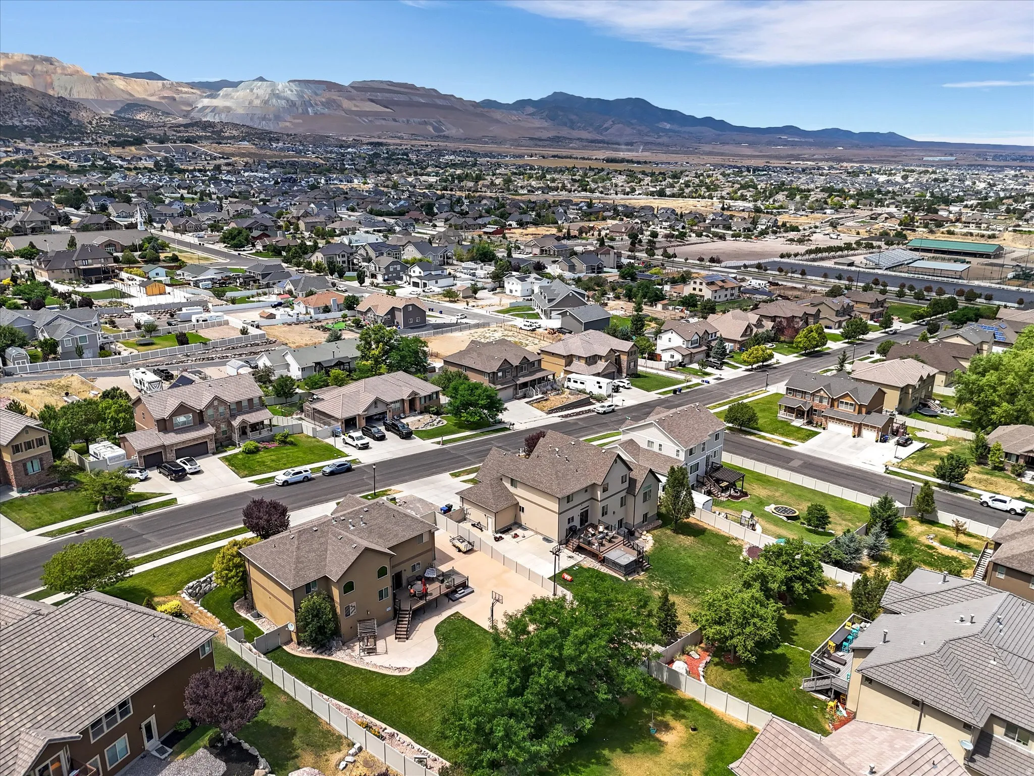 Residential neighborhood with mature trees and paved streets, framed by distant mountains