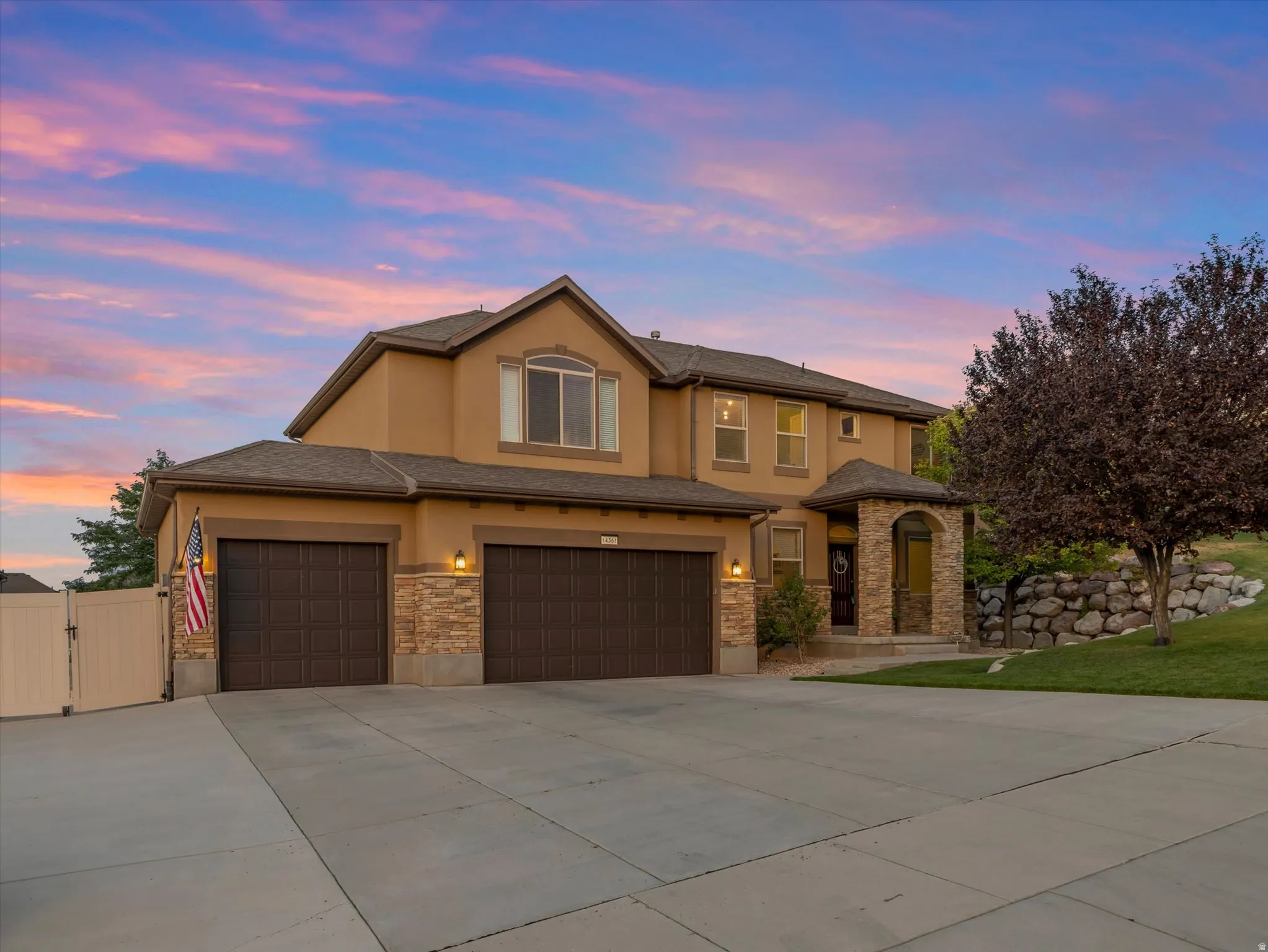 Two-story stucco exterior featuring multiple windows and a prominent entry archway