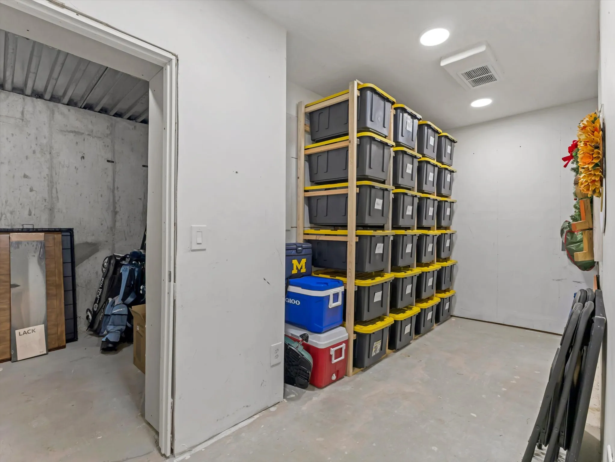 Dedicated storage area featuring concrete flooring and exposed concrete walls