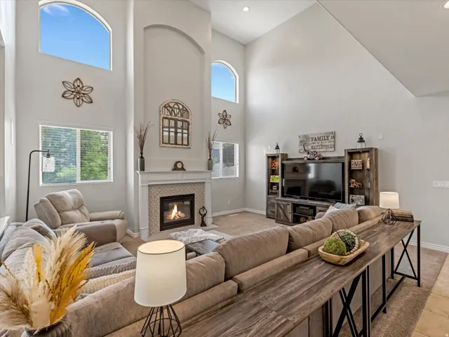 Vaulted ceilings featuring arched windows and a fireplace with tile surround