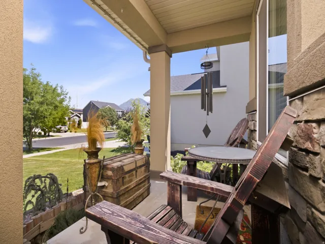 Covered porch with concrete flooring and a stone veneer exterior wall
