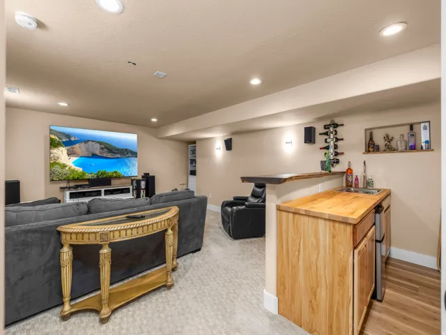 Entertainment space featuring recessed lighting, a large wall-mounted screen, and carpeted flooring