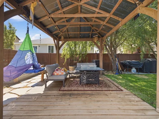 Expansive wood-plank gazebo featuring a corrugated metal roof, open beam construction, and integrated lighting
