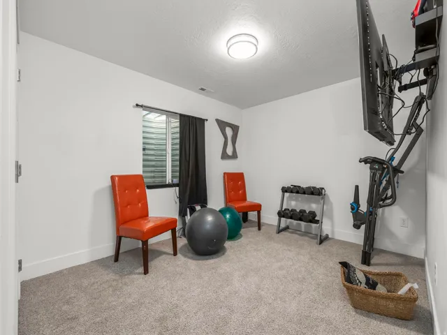 Carpeted room featuring a ceiling-mounted light fixture, white walls, and white trim