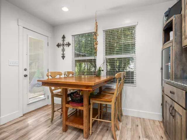 Bright dining area featuring wood-finish flooring and a glass-paneled exterior door