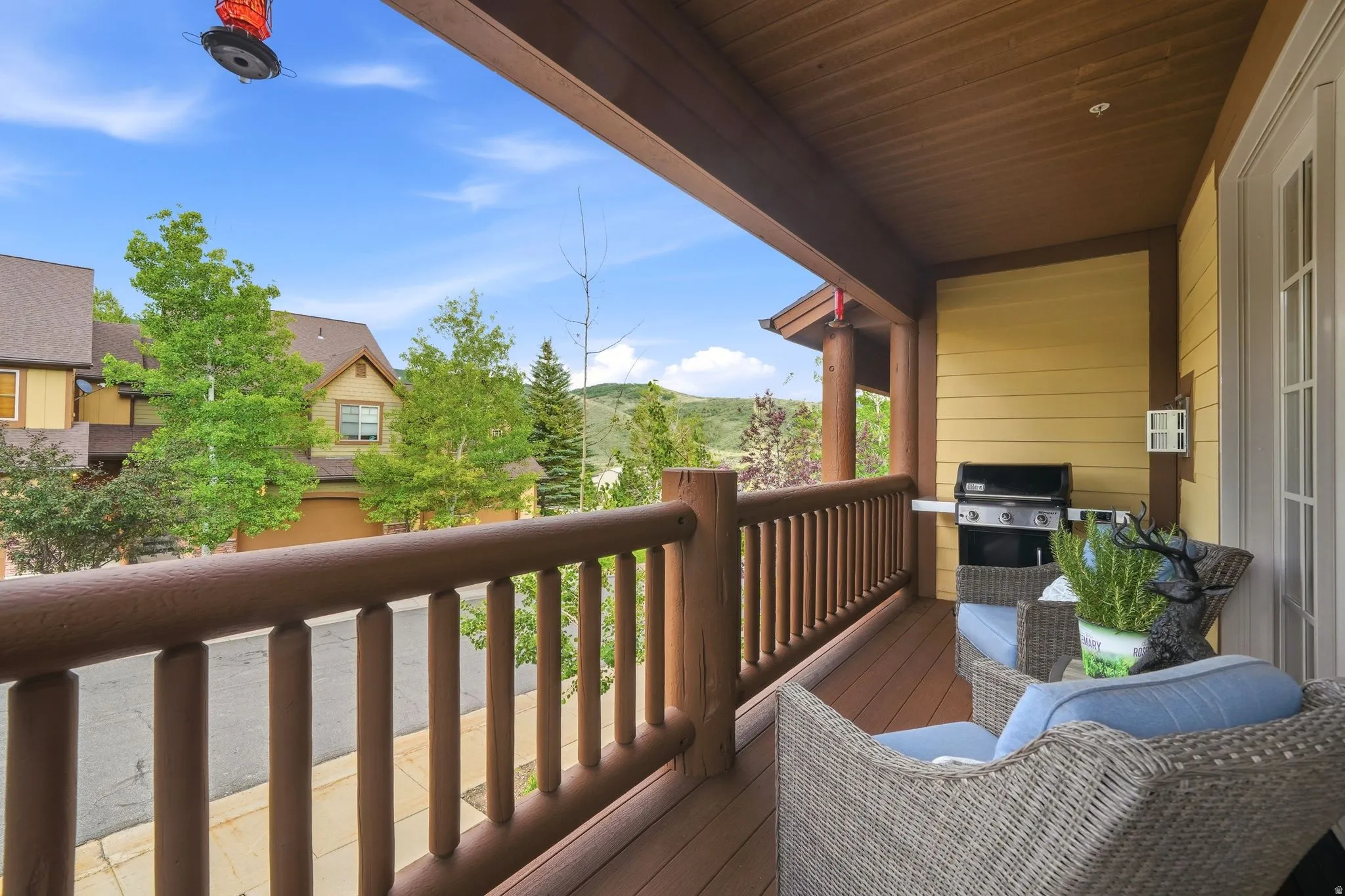 Covered outdoor deck with wood-finish railing and columns